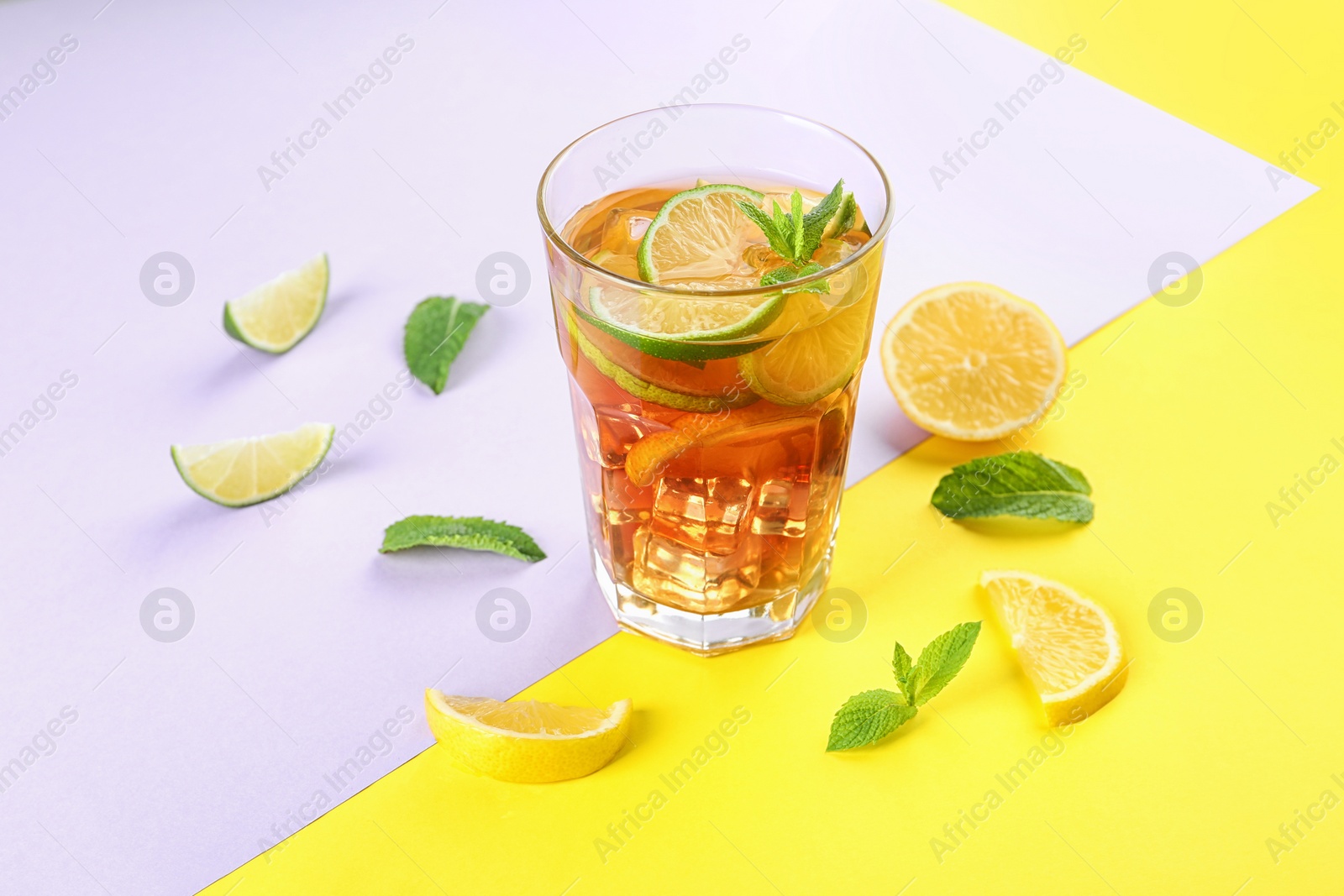 Photo of Glass of refreshing iced tea on color table