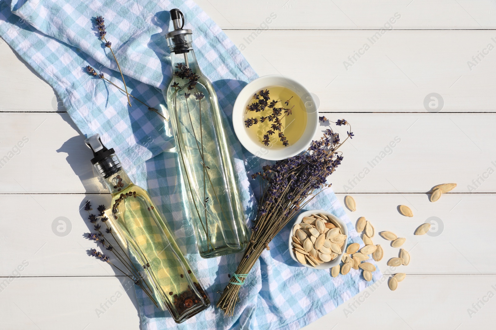 Photo of Different cooking oils and ingredients on white wooden table, flat lay