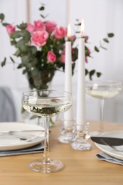 Photo of Place setting with pink roses on wooden table. Romantic dinner
