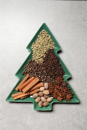 Photo of Different spices and nuts on light gray textured table, top view