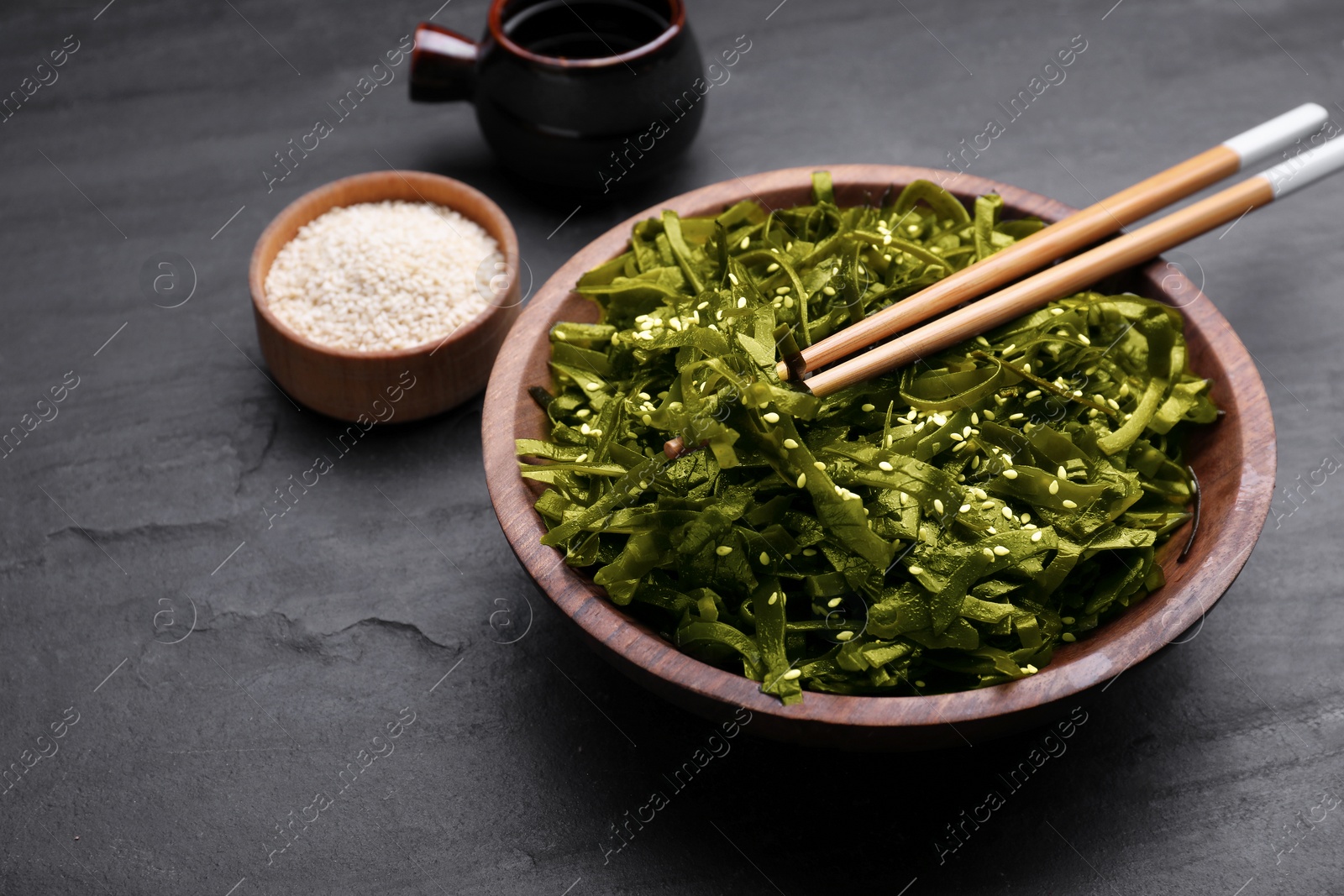 Photo of Fresh laminaria (kelp) seaweed served on black table