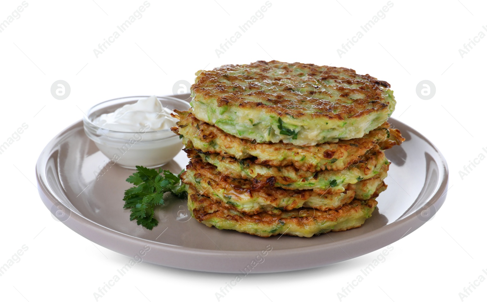 Photo of Delicious zucchini fritters with sour cream on white background