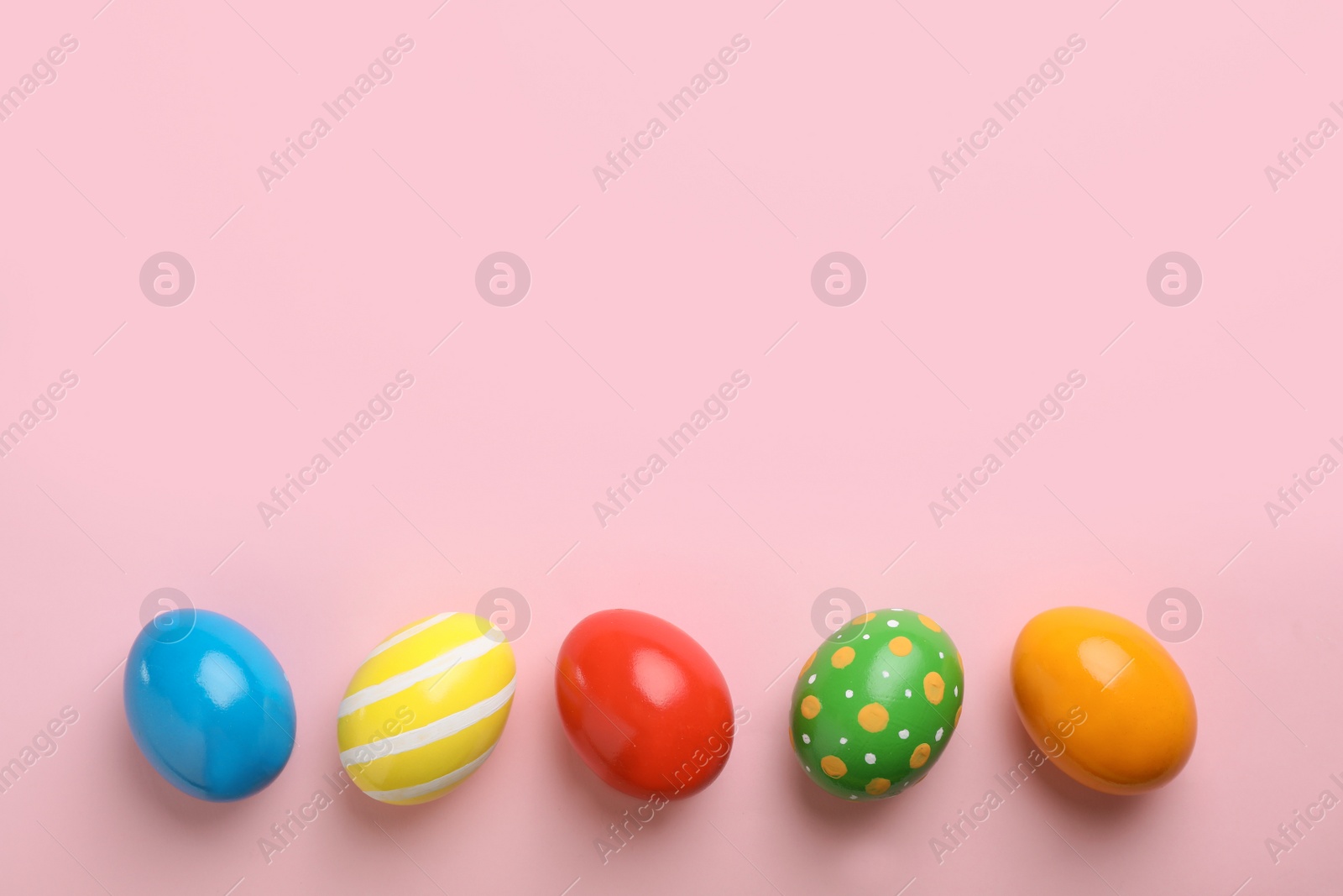 Photo of Decorated Easter eggs and space for text on color background, top view