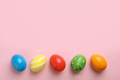 Photo of Decorated Easter eggs and space for text on color background, top view