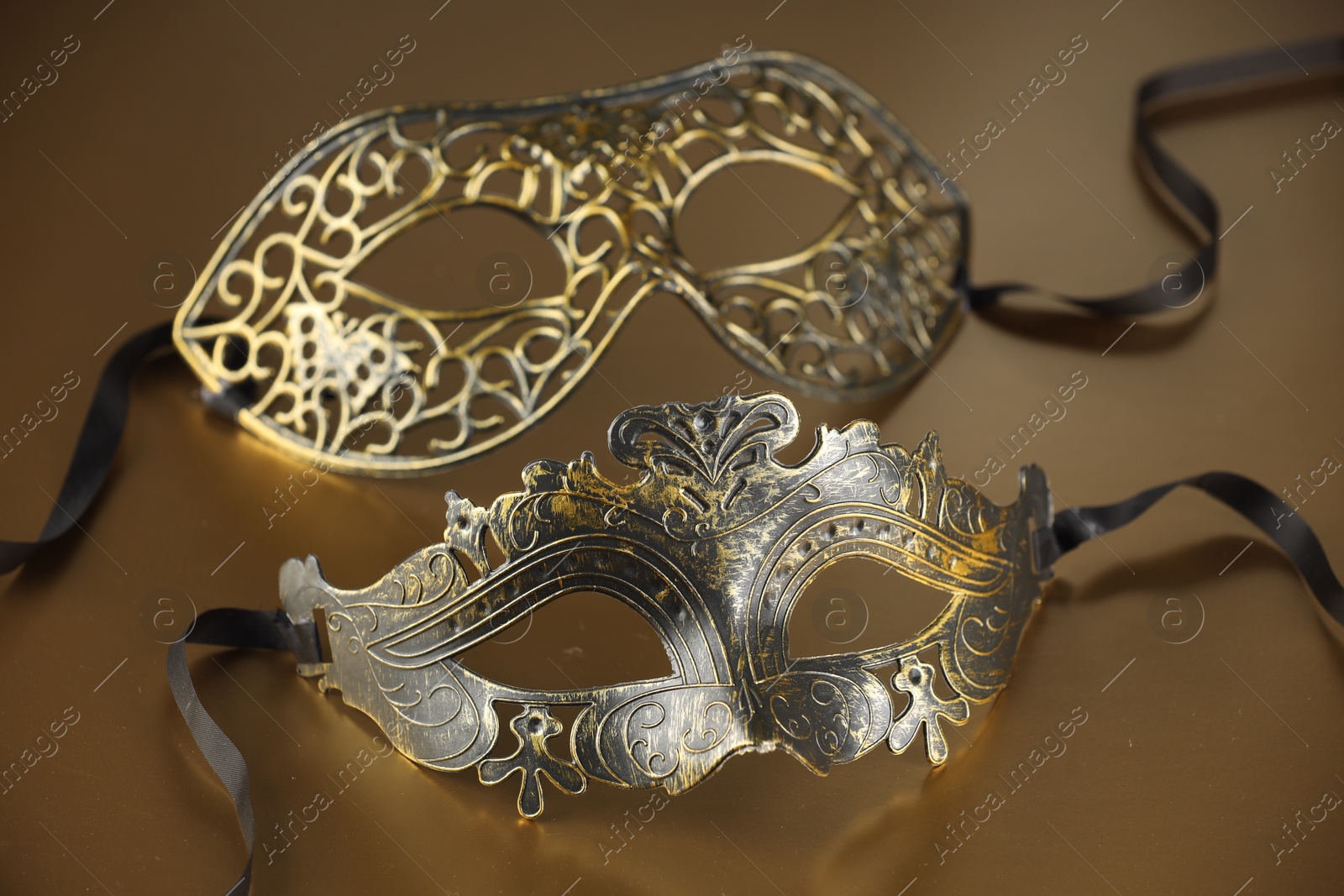 Photo of Elegant face masks on beige background. Theatrical performance