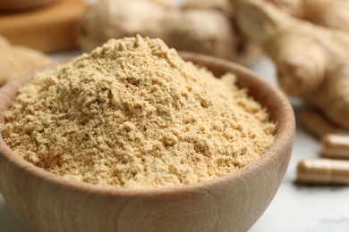 Dry ginger powder in bowl on table, closeup