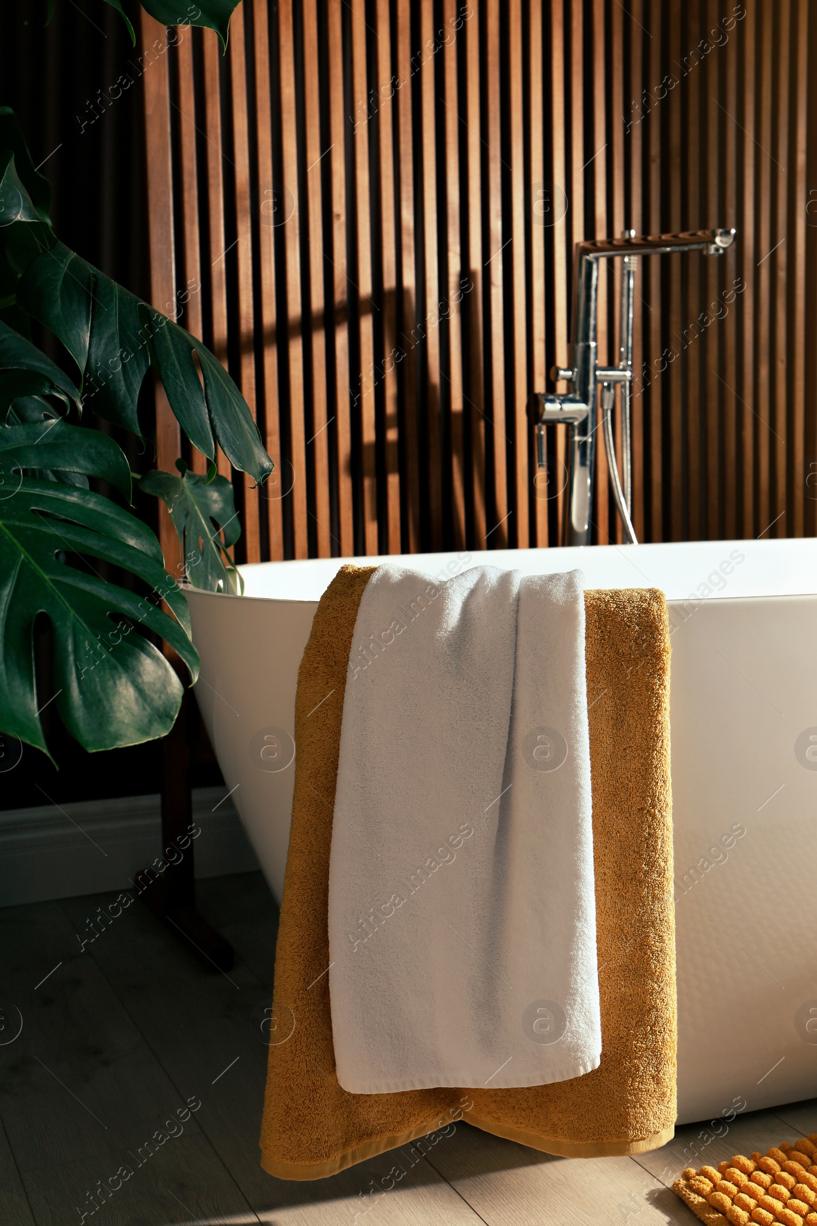 Photo of Cozy bathroom interior with stylish ceramic tub