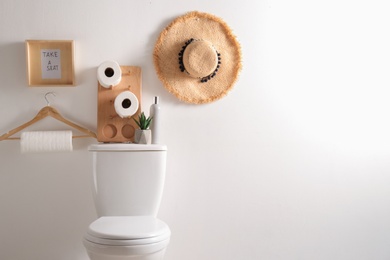 Photo of Decor elements, necessities and toilet bowl near white wall, space for text. Bathroom interior