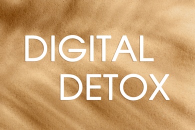 Text Digital Detox and golden beach sand with tropical palm leaf shadow on background, top view