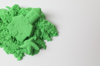 Photo of Castle and starfish made of green kinetic sand isolated on white, top view