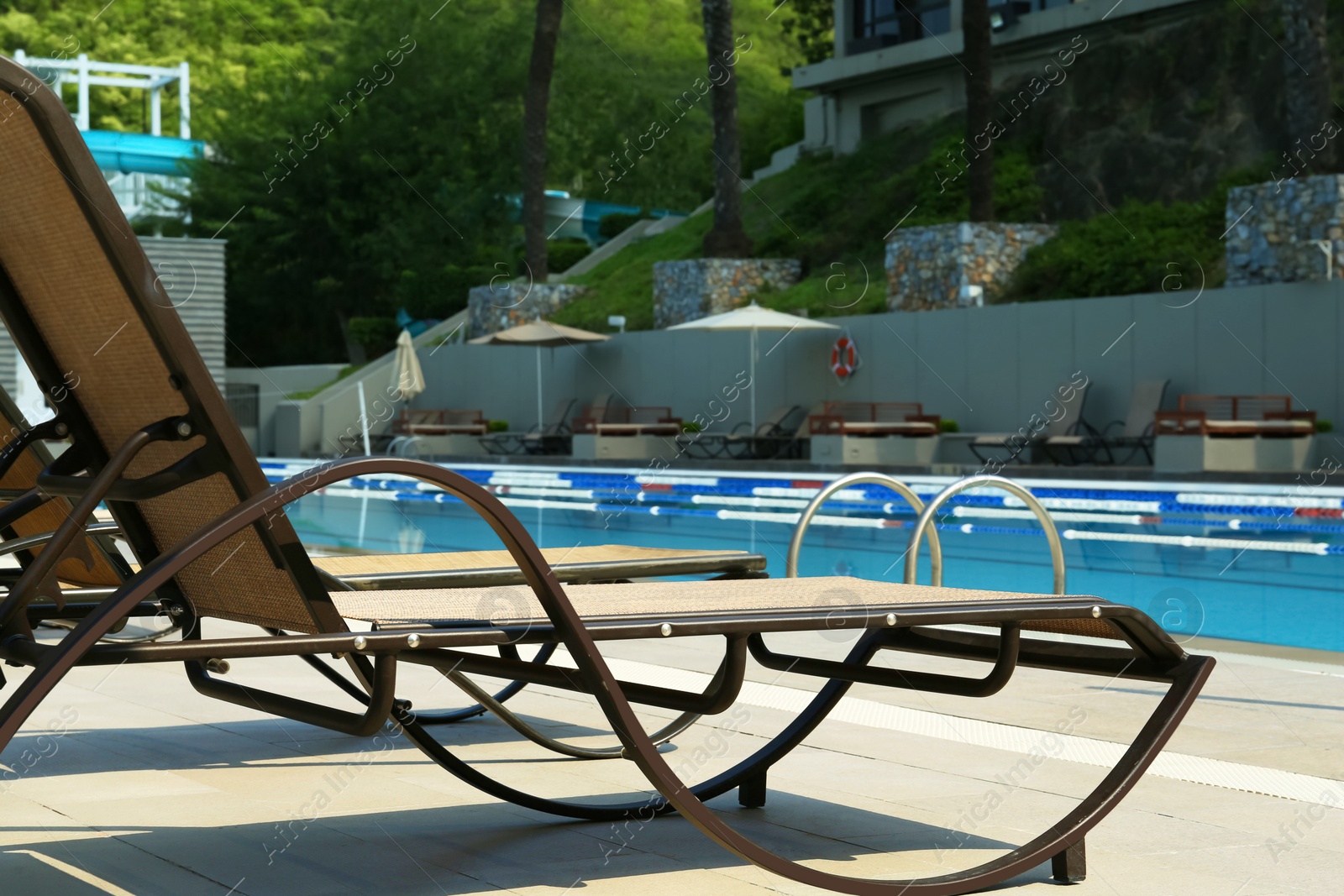 Photo of Empty sunbeds near outdoor swimming pool at resort