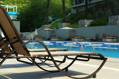 Photo of Empty sunbeds near outdoor swimming pool at resort