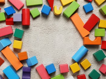 Photo of Frame of colorful wooden building blocks on carpet, flat lay. Space for text