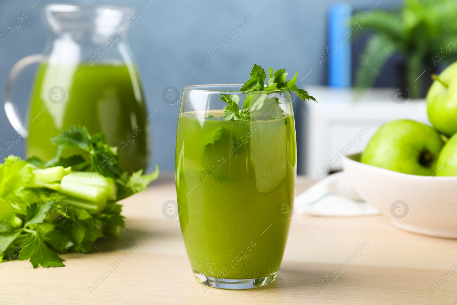 Photo of Glass of fresh celery juice on white table, closeup