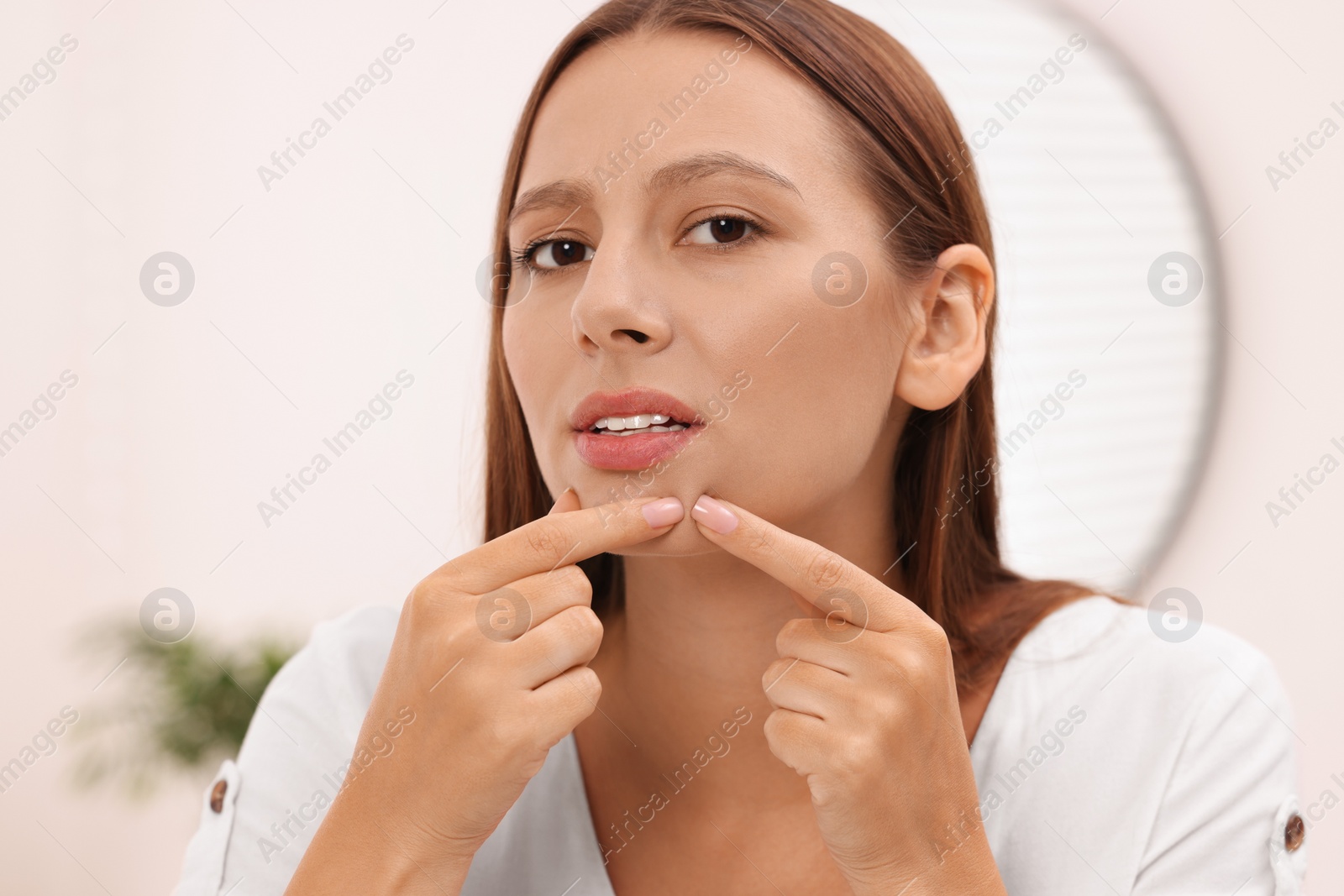 Photo of Woman with skin problem indoors, view from mirror