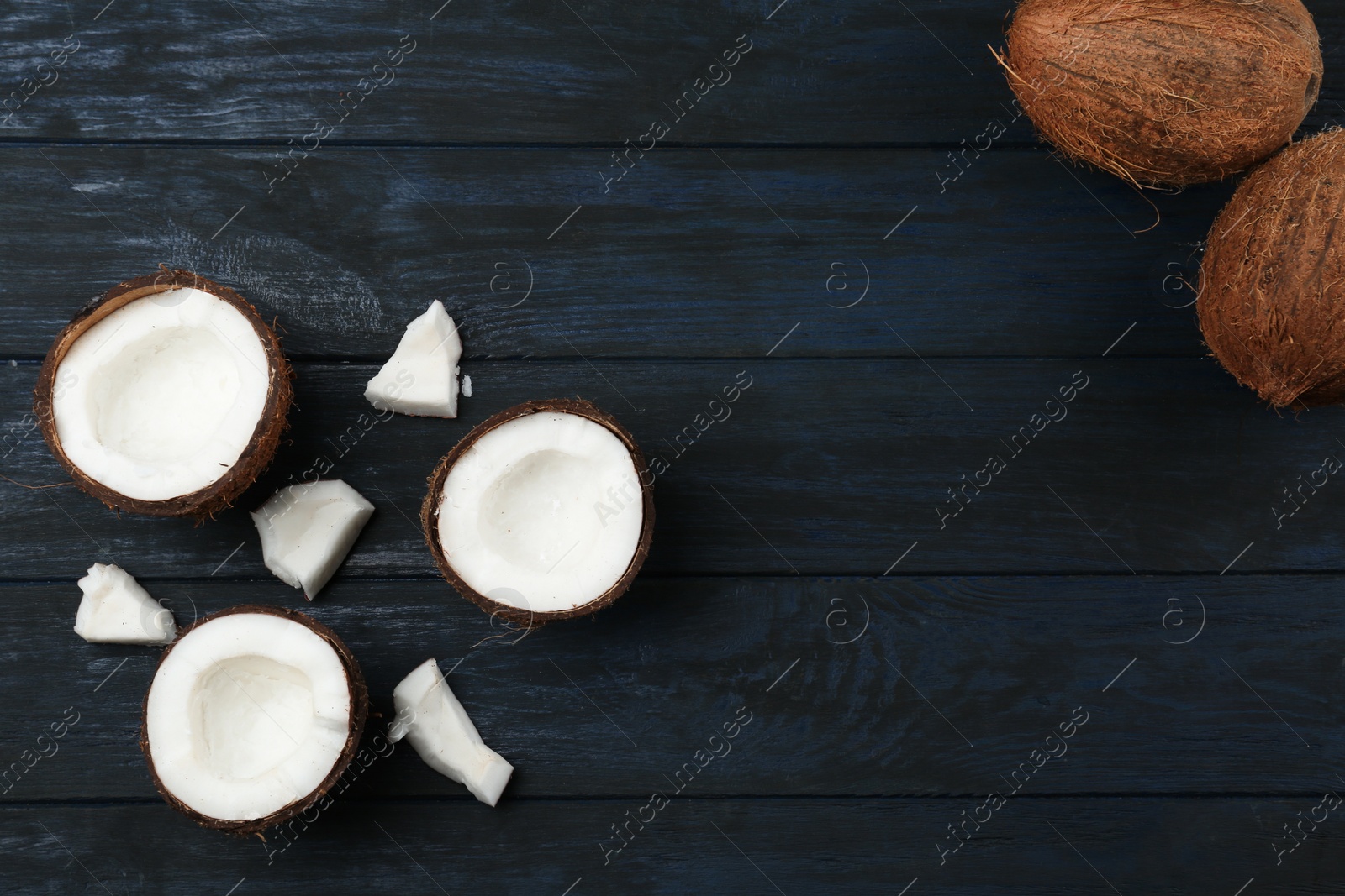 Photo of Flat lay composition with coconuts on dark wooden table, space for text. Cooking ingredients