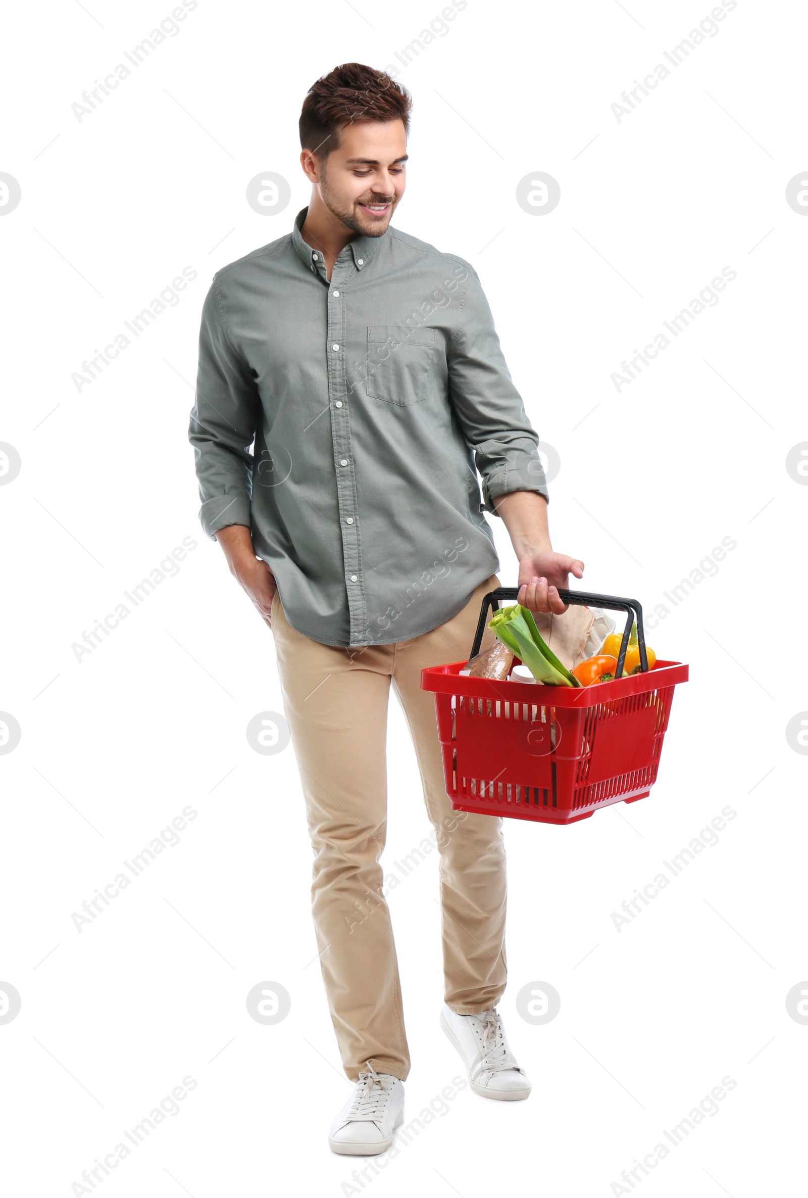 Photo of Young man with shopping basket full of products isolated on white