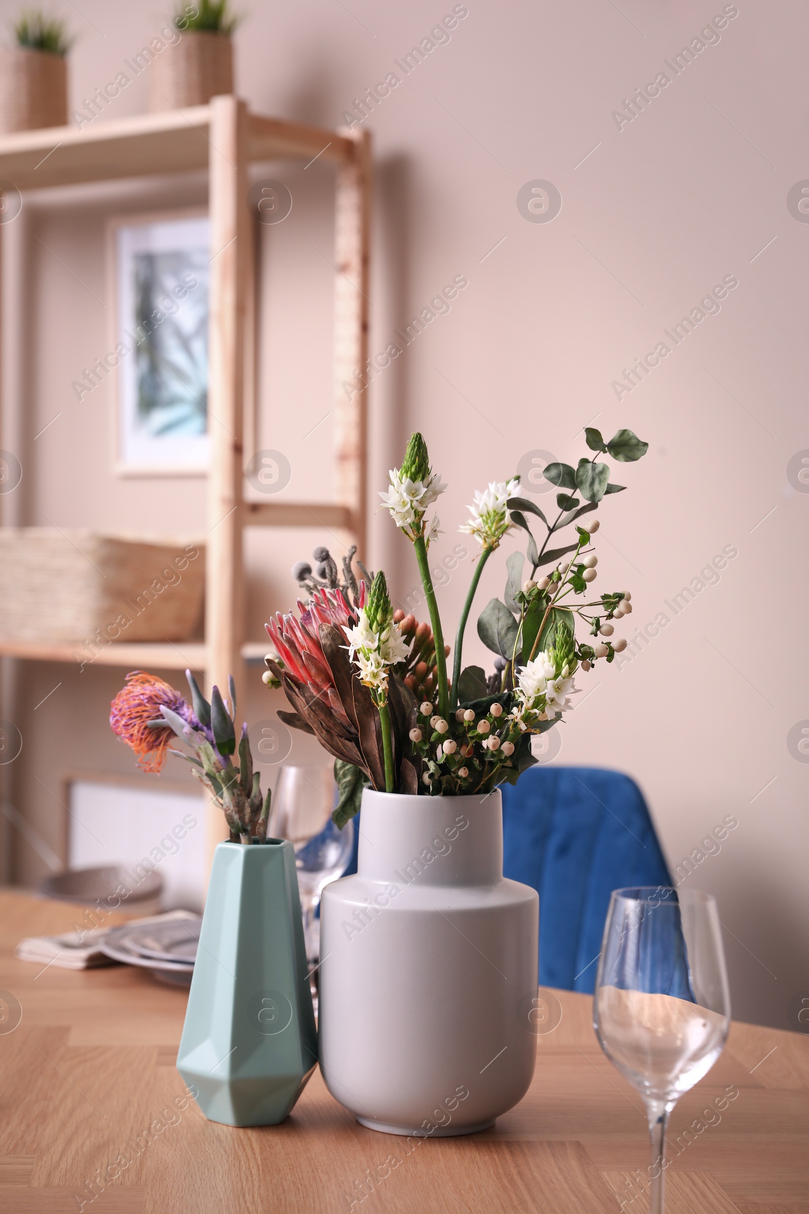 Photo of Vase with beautiful flowers on wooden table indoors. Element of modern interior