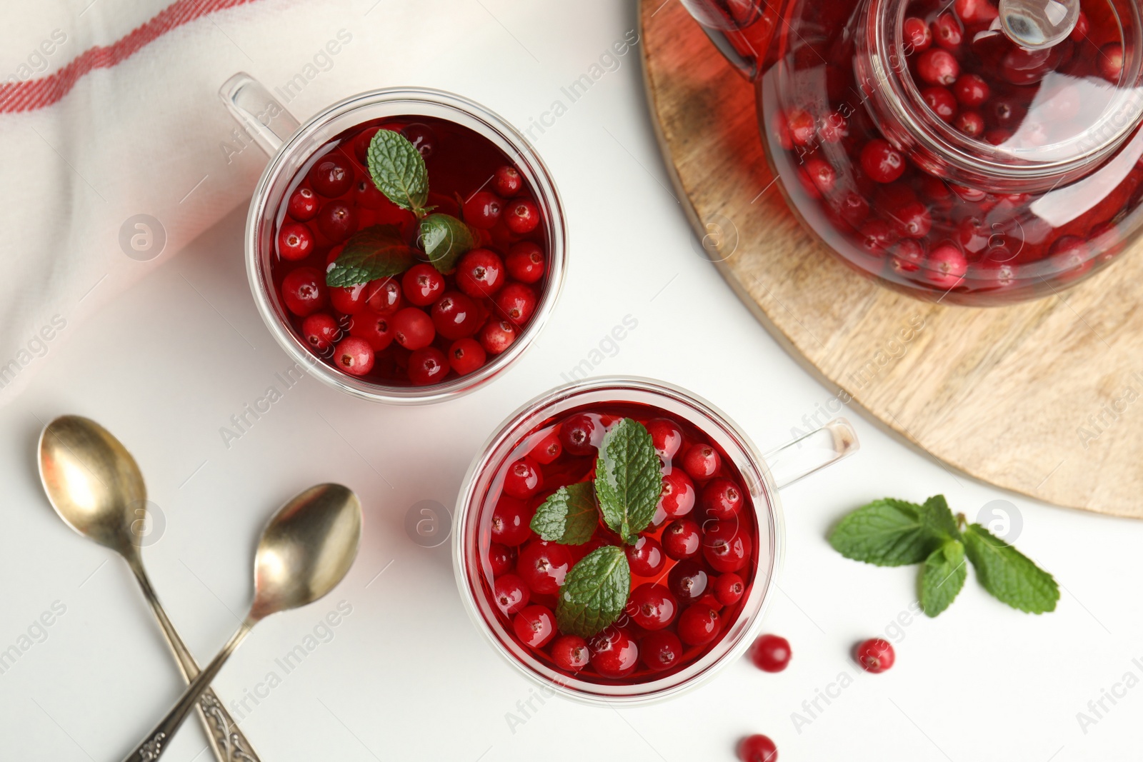 Photo of Tasty hot cranberry tea and fresh ingredients on light table, flat lay