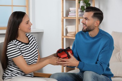 Photo of Lovely couple with beautiful gift at home