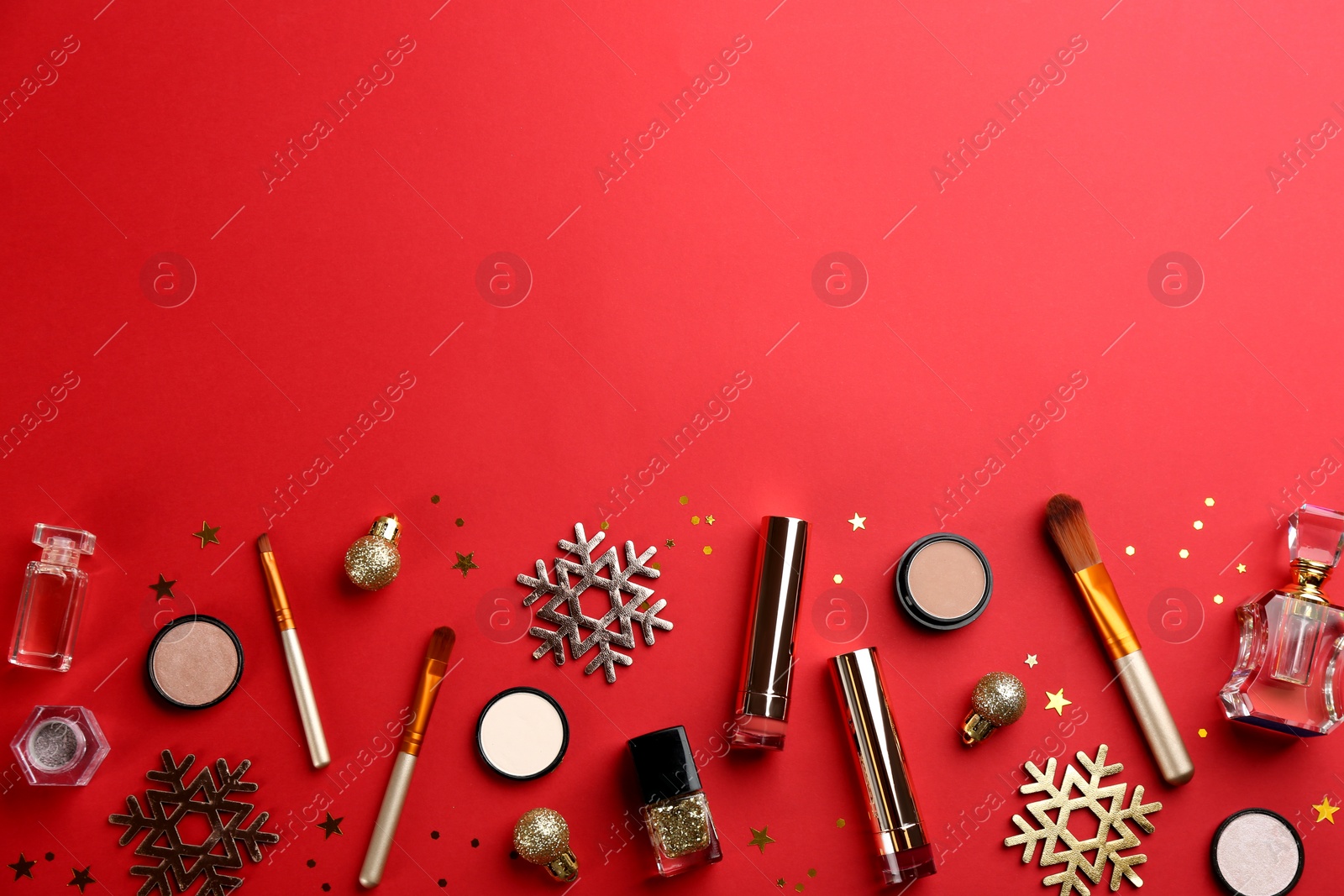 Photo of Flat lay composition with decorative cosmetic products on red background, space for text. Winter care