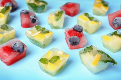 Photo of Fruit and berry ice cubes on color background