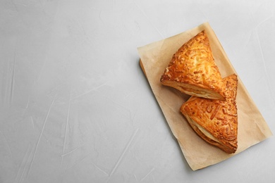 Photo of Fresh delicious puff pastry on grey table, top view. Space for text