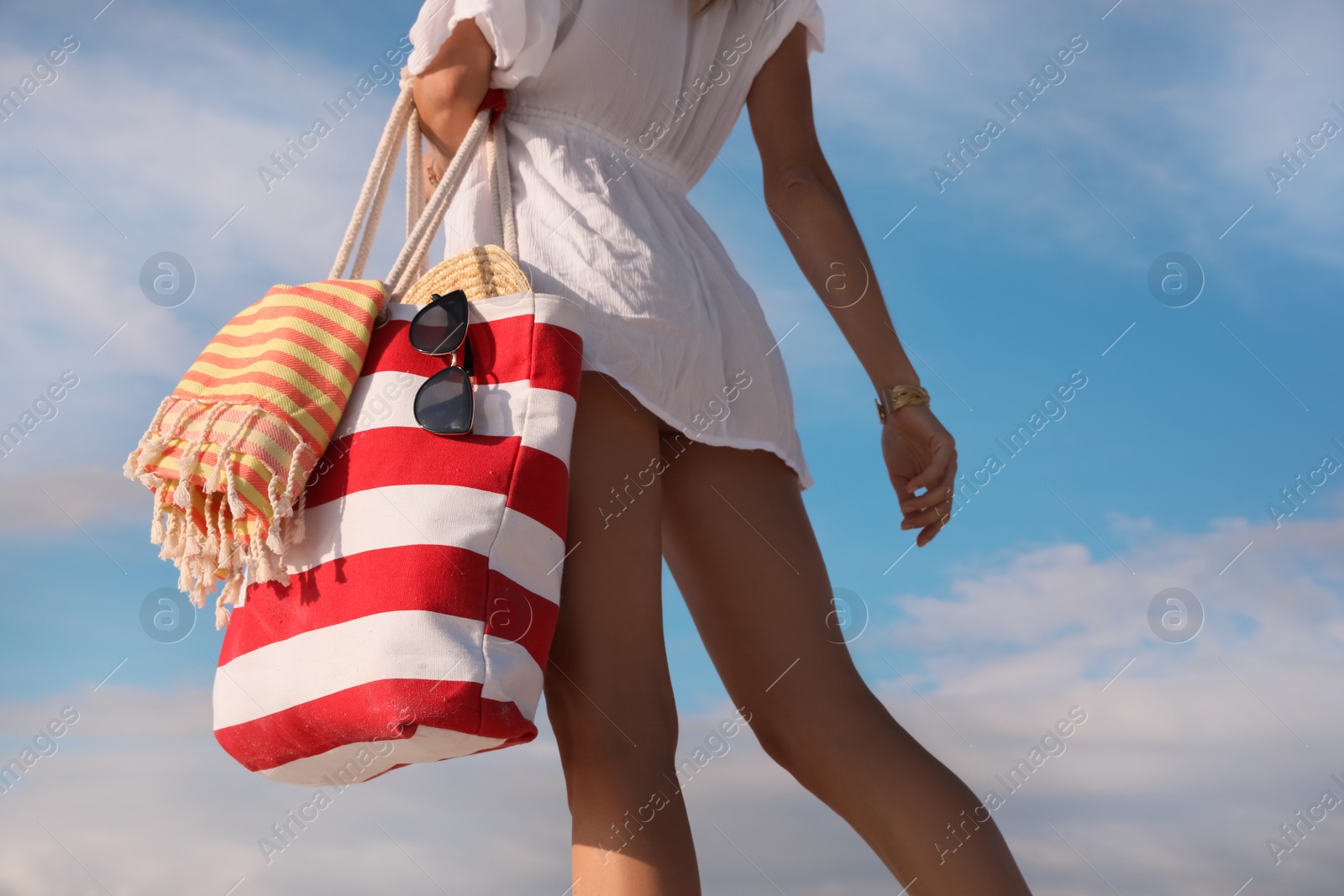 Photo of Woman with beach bag against blue sky, closeup