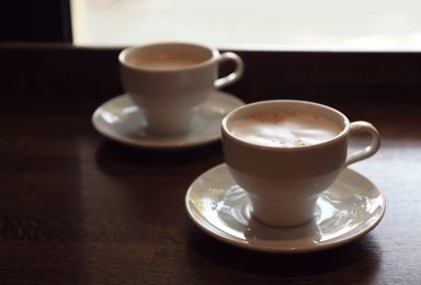 Photo of Cups of fresh aromatic coffee on table