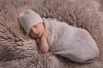 Photo of Adorable newborn baby lying on faux fur, top view