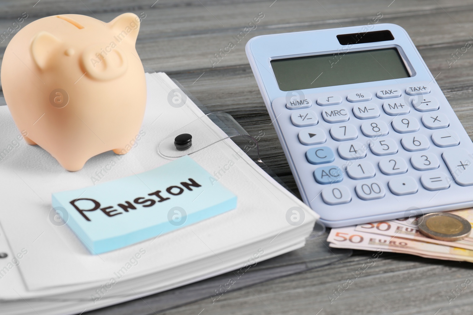 Photo of Calculator, piggy bank, euro banknotes, coins, folder and notes with word Pension on wooden table. Retirement concept