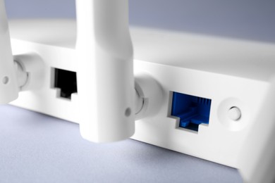 Photo of Wi-Fi router on light grey background, closeup