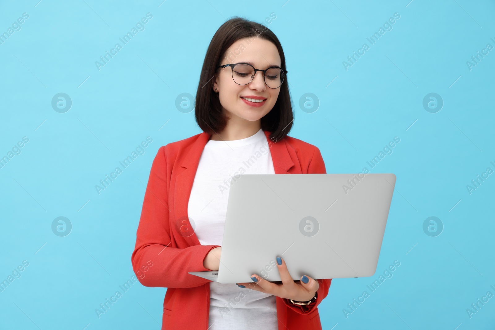 Photo of Happy young intern with laptop on light blue background