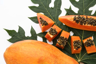 Fresh ripe cut and whole papaya fruits with leaf on white background