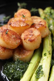 Photo of Delicious fried scallops with asparagus and sauce on plate, closeup