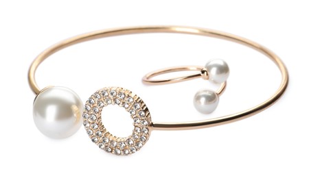 Photo of Elegant golden bracelet and ring with pearls on white background