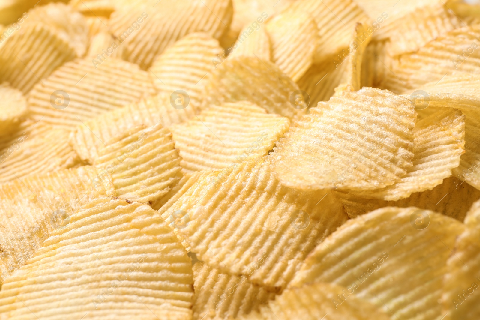 Photo of Pile of crispy potato chips as background, closeup