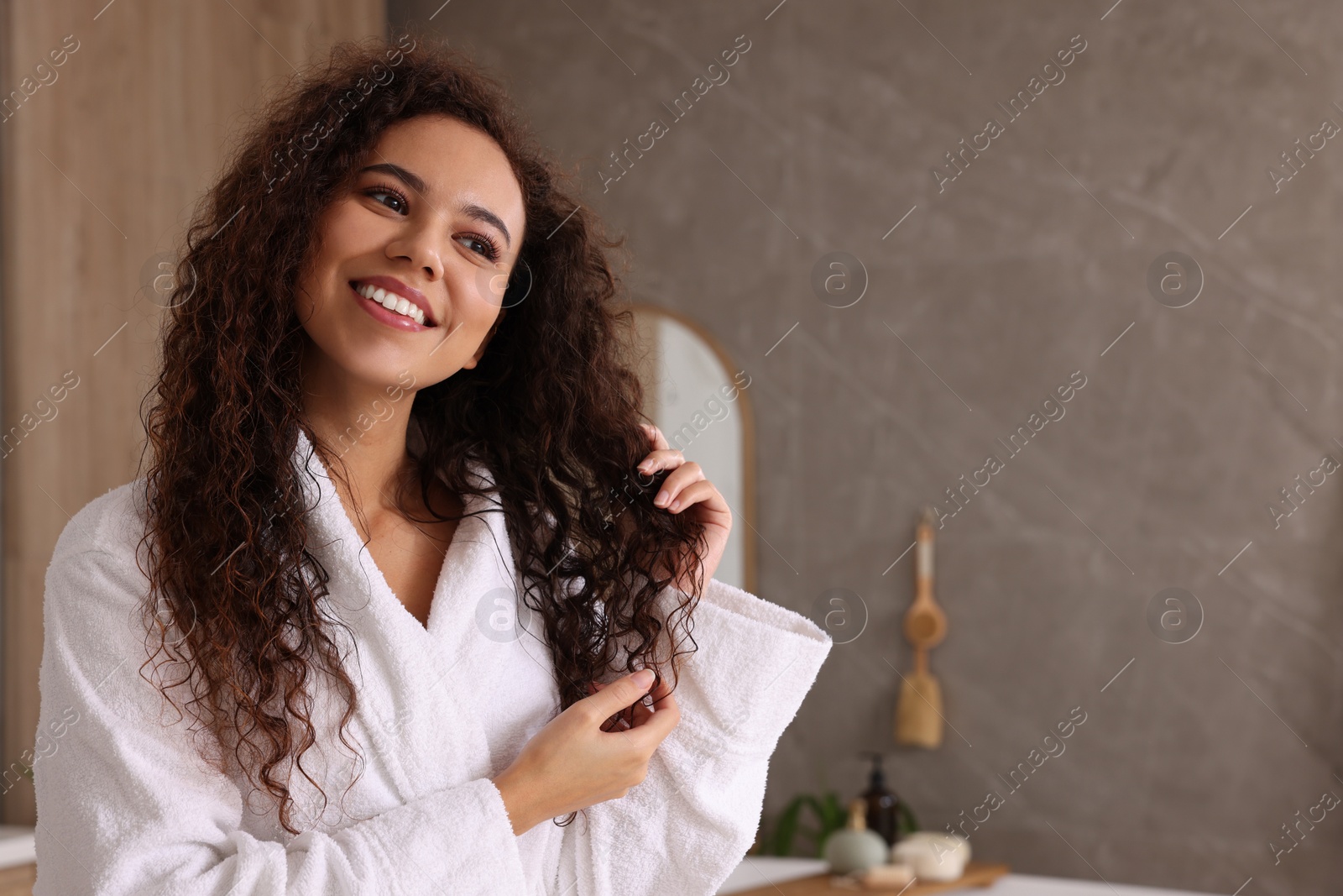 Photo of Beautiful African American woman in bathroom, space for text
