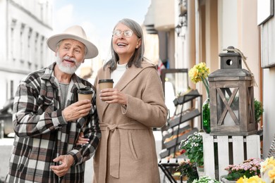 Photo of Affectionate senior couple drinking coffee outdoors, space for text