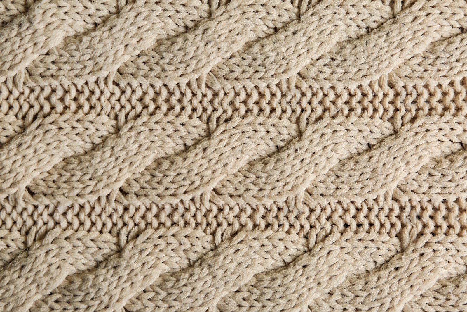 Photo of Beige knitted fabric with beautiful pattern as background, top view