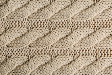 Beige knitted fabric with beautiful pattern as background, top view