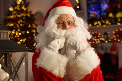 Photo of Santa Claus winking in room decorated for Christmas