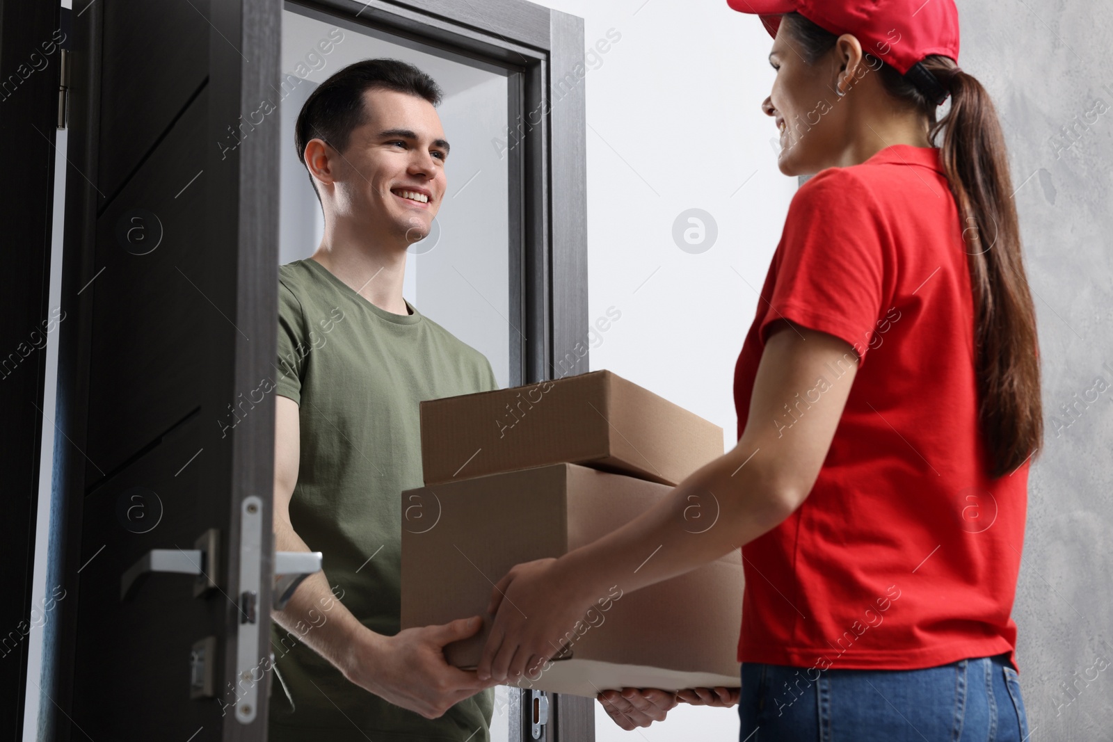 Photo of Courier giving parcels to man at house entrance