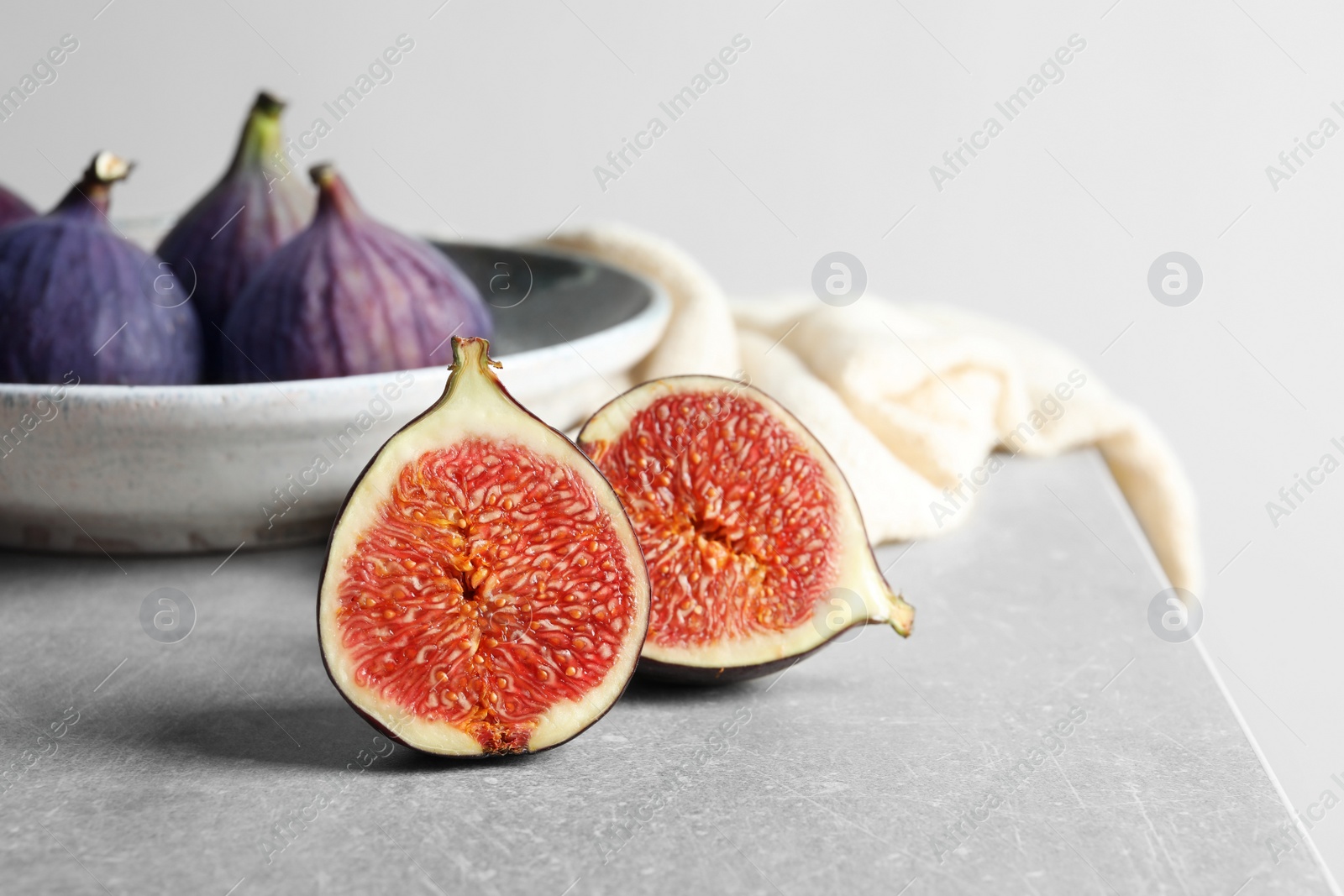 Photo of Fresh ripe fig sliced in half on table. Tropical fruit