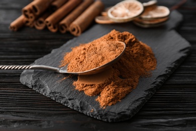 Photo of Aromatic cinnamon powder and sticks on wooden background