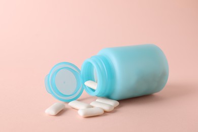 Jar with chewing gums on light pink background