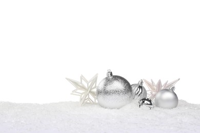Photo of Beautiful silver Christmas balls and decorative snowflakes on snow against white background
