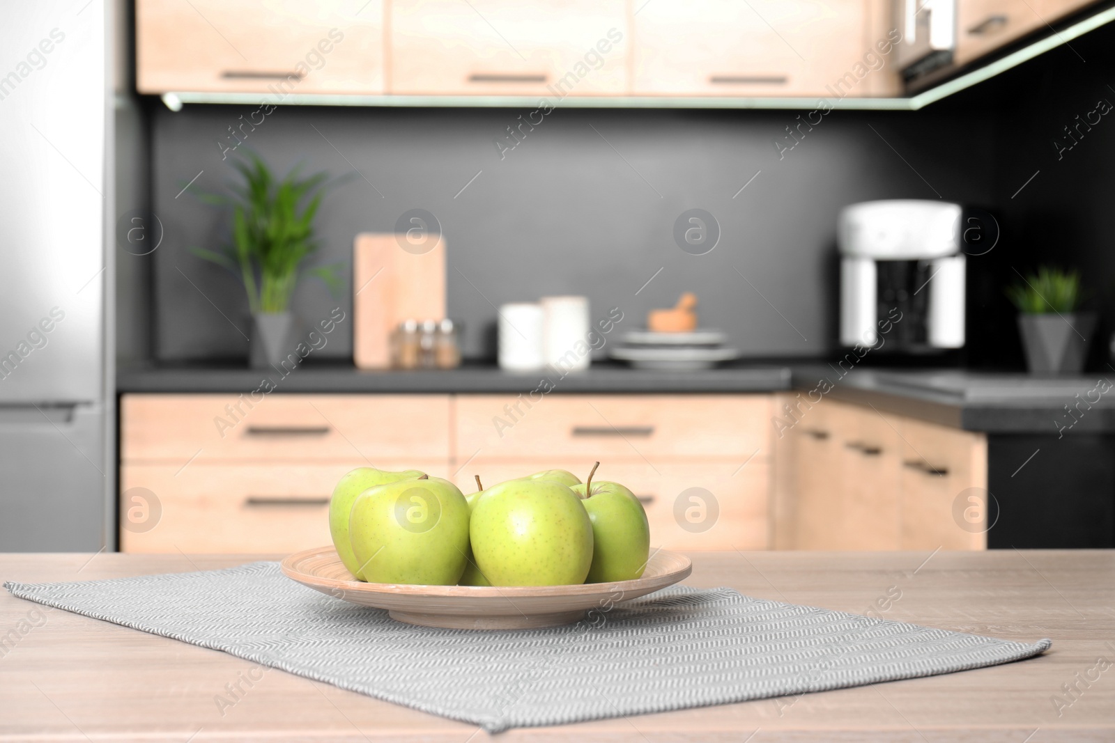 Photo of Fresh green apples on wooden table in kitchen