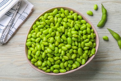 Photo of Organic edamame beans on light wooden table, flat lay