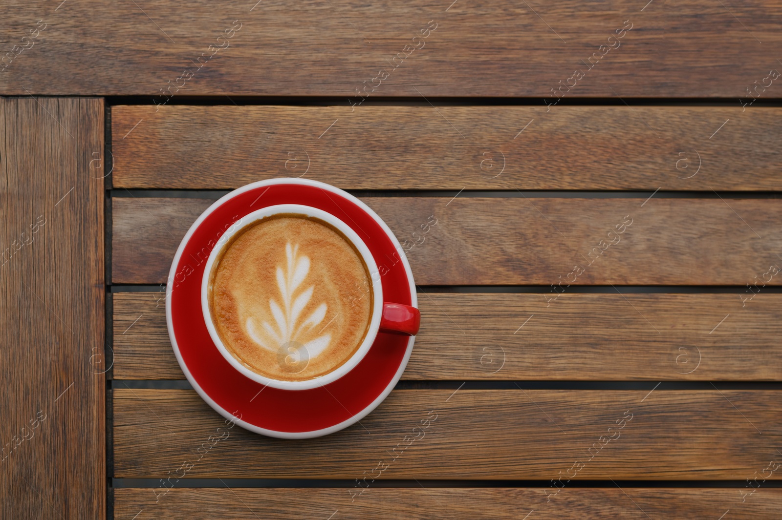 Photo of Cup of aromatic coffee on wooden table, top view. Space for text